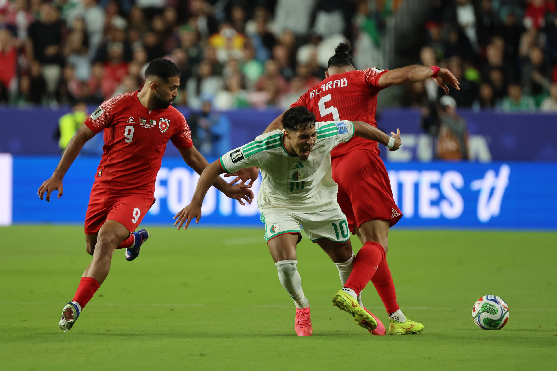 El jordano Yazan Alarab (d)  busca superar la marca del argelino Fares Chaibi (c) durante el partido de la segunda jornada del Mundial jugado este lunes en el estadio Levi's en Santa Clara. EFE/ Miguel Gutiérrez
