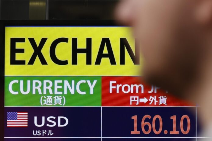 Imagen de archivo de un peatón junto a un panel electrónico que muestra el tipo de cambio entre el dólar estadounidense y el yen japonés después de que el índice Nikkei 225 superara los 71.000 puntos en Tokio, Japón, el 18 de junio de 2026. 
EFE/EPA/RODRIGO REYES MARIN
