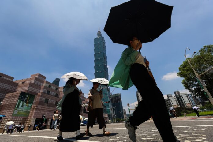 TAIPEI (Taiwán), 22/06/2026.- Varias personas caminan con paraguas bajo un calor abrasador en Taipéi, Taiwán, el 22 de junio de 2026, antes de la llegada prevista de la tormenta tropical Mekkhala a finales de esta semana. 
EFE/EPA/RITCHIE B. TONGO
