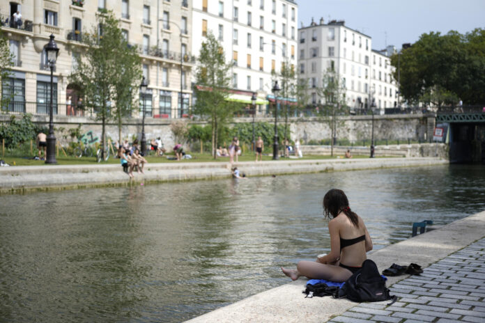 Varios parisinos se refrescan a orillas del Sena en París, este martes. Francia vivió este martes la madrugada más calurosa desde que empezaron los registros a nivel nacional en 1947, con una mínima de 21,6 grados de media, que superó el anterior récord de 21,4 grados del 25 de julio de 2019, indicó Météo France. EFE/ Edgar Sapiña
