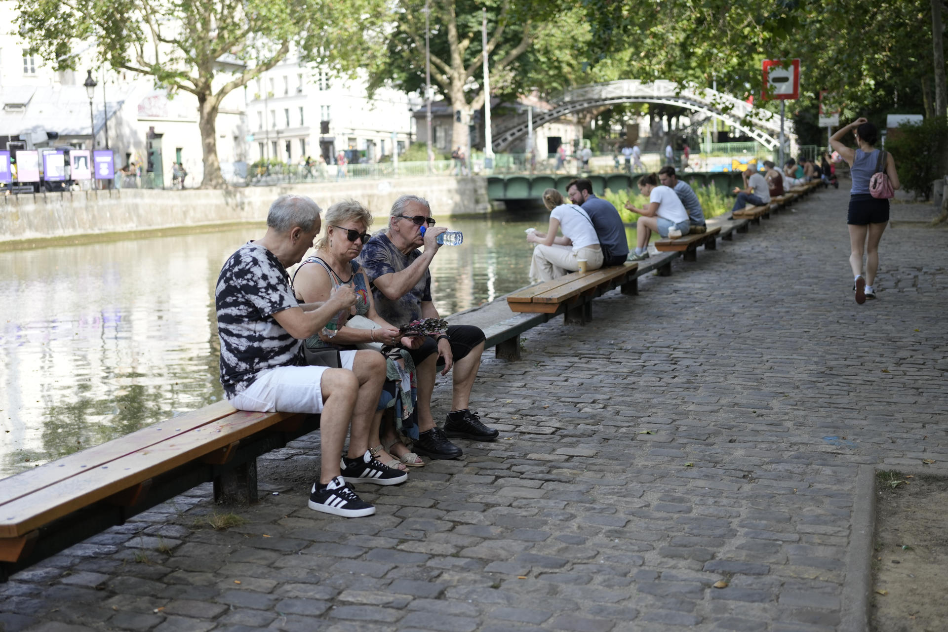 Varias personas descansan a orillas del Sena en París, este martes. Francia vivió este martes la madrugada más calurosa desde que empezaron los registros a nivel nacional en 1947, con una mínima de 21,6 grados de media, que superó el anterior récord de 21,4 grados del 25 de julio de 2019, indicó Météo France. EFE/ Edgar Sapiña
