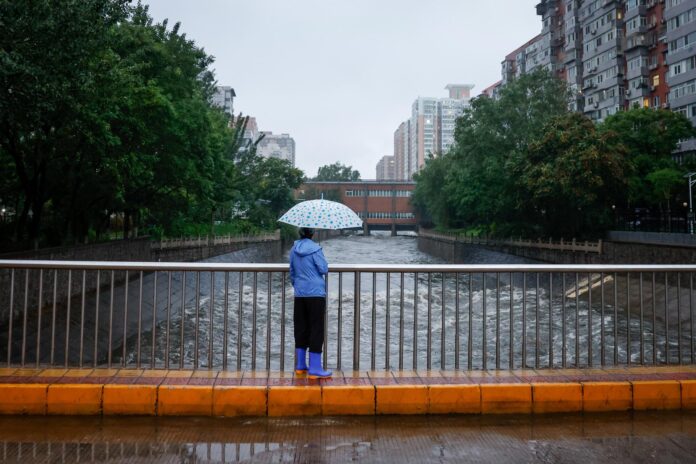 Una mujer observando cómo se vierte agua en un río en Pekín, China., en una fotografía de archivo. EFE/EPA/MARK R. CRISTINO
