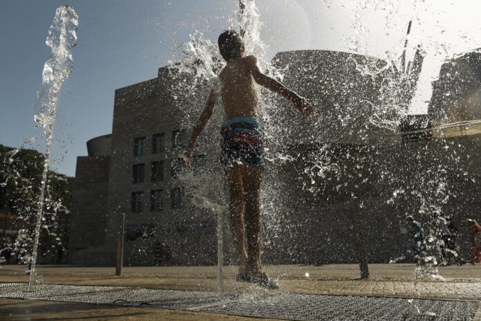Un joven se refresca en una fuente frente al Museo Guggenheim Bilbao (norte de España), este martes. EFE/ Miguel Toña
