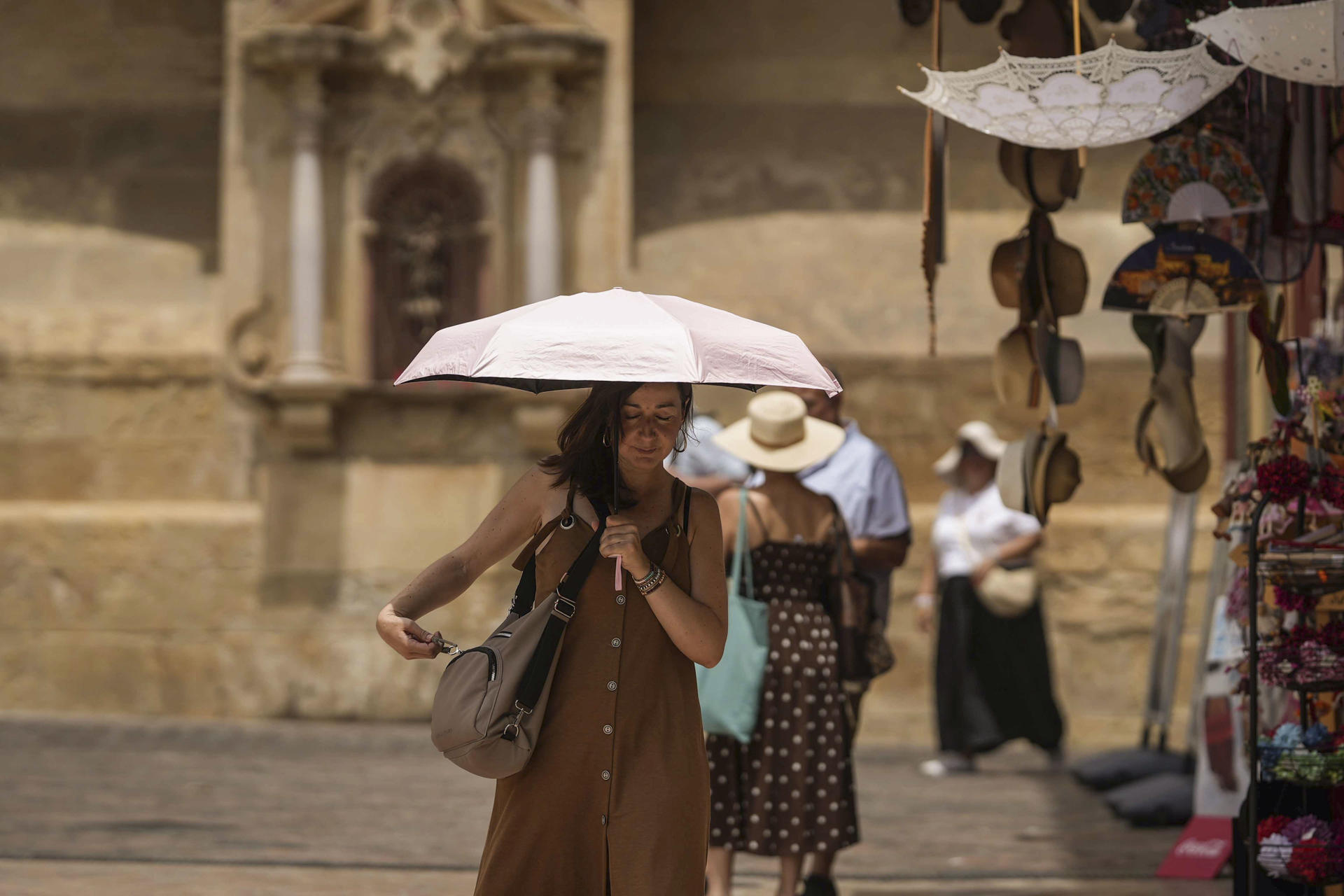 Una turista se protege del sol en Córdoba (Andalucía, sur de España), este martes. EFE/Rafa Alcaide
