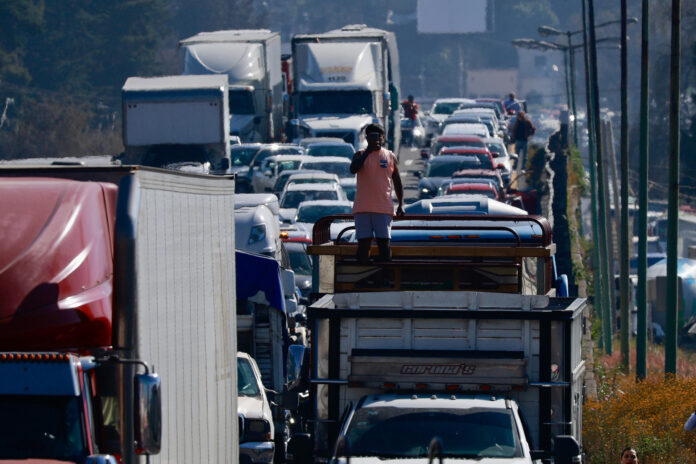 Una persona toma una fotografía durante un bloqueo realizado por transportistas en una carretera del municipio de Lerma (México). Imagen de archivo. EFE/Felipe Gutiérrez
