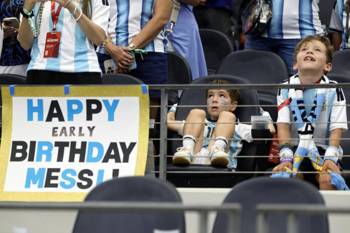 Aficionados de Argentina reaccionan cerda de un cartel alusivo al cumpleaños de Lionel Messi este lunes, durante el enfrentamiento entre Argentina y Austria, en Dallas (Estados Unidos). . EFE/ Mariscal
