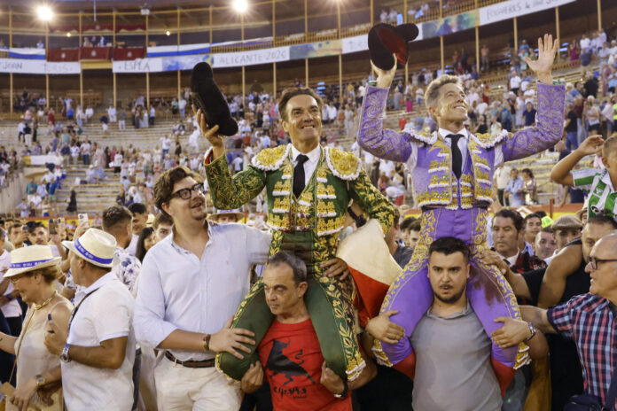 Los diestros Manuel Escribano (d) y Manuel Jesús El Cid salen a hombros al finalizar el festejo taurino de la Feria de las Hogueras celebrado este miércoles en la plaza de toros de Alicante. EFE/ Pablo Miranzo
