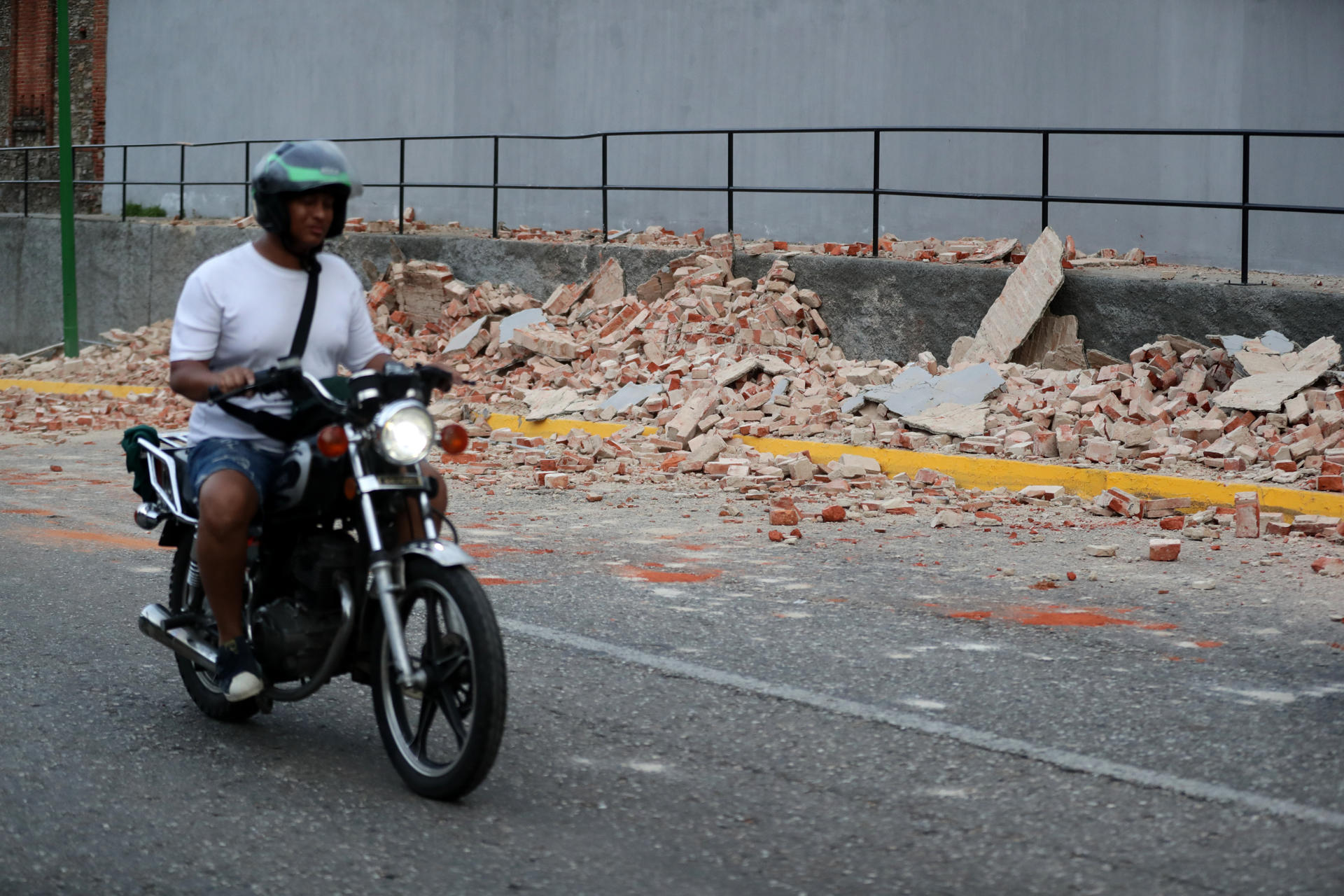 Un motociclista transita cerca de escombros este miércoles, en Caracas (Venezuela). EFE/ Ronald Peña R

