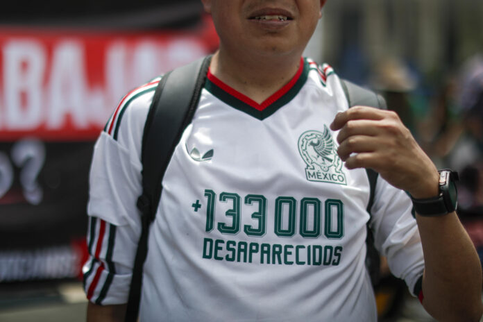 Una persona viste una camiseta con un mensaje en protesta por desaparecidos durante una manifestación rumbo al estadio Ciudad de México (México). Imagen de archivo. EFE/Isaac Esquivel
