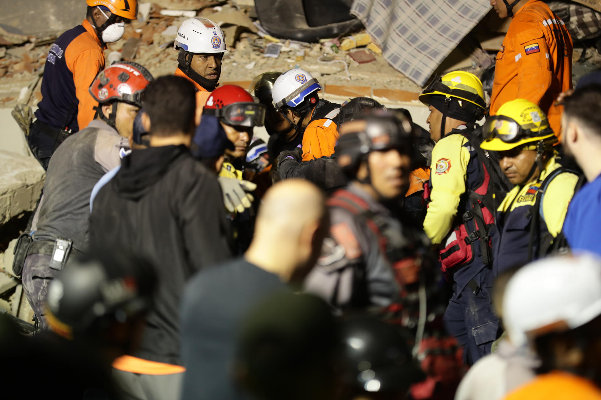 Integrantes de cuerpos de emergencia buscan víctimas este miércoles, luego de dos fuertes terremotos sacudieron el Caribe venezolano en Caracas (Venezuela). El evento principal fue un sismo de magnitud 7,5, informó el sistema oficial de alerta de tsunamis de Estados Unidos. EFE/ Ronald Peña R
