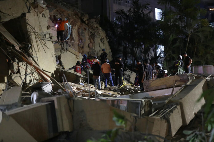 Integrantes de cuerpos de emergencia buscan víctimas este miércoles, luego de dos fuertes terremotos que sacudieron el Caribe venezolano en Caracas (Venezuela). El evento principal fue un sismo de magnitud 7,5, informó el sistema oficial de alerta de tsunamis de Estados Unidos. EFE/ Ronald Peña R
