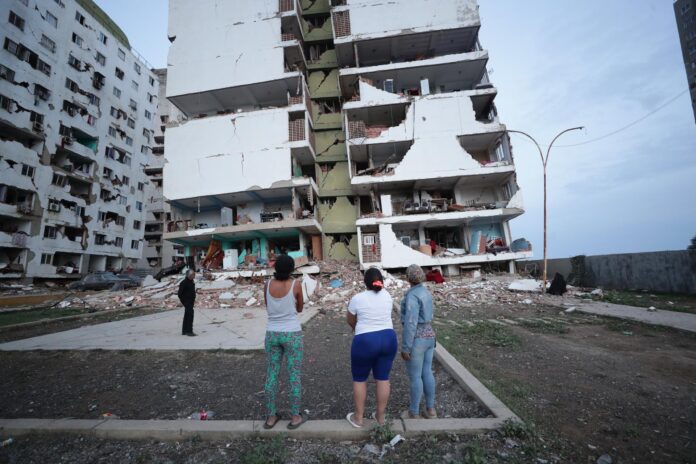 Residentes observan varios bloques de viviendas dañados por los terremotos en la localidad de Catia La Mar, en el estado costero de La Guaira (Venezuela) este jueves. EFE/ Ronald Pena R.
