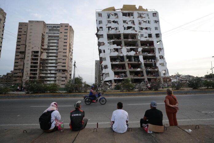 Residentes observan uno de los bloques de viviendas dañados por los terremotos, en la localidad de Catia La Mar, en el estado costero de La Guaira (Venezuela) este jueves. EFE/ Ronald Pena R.
