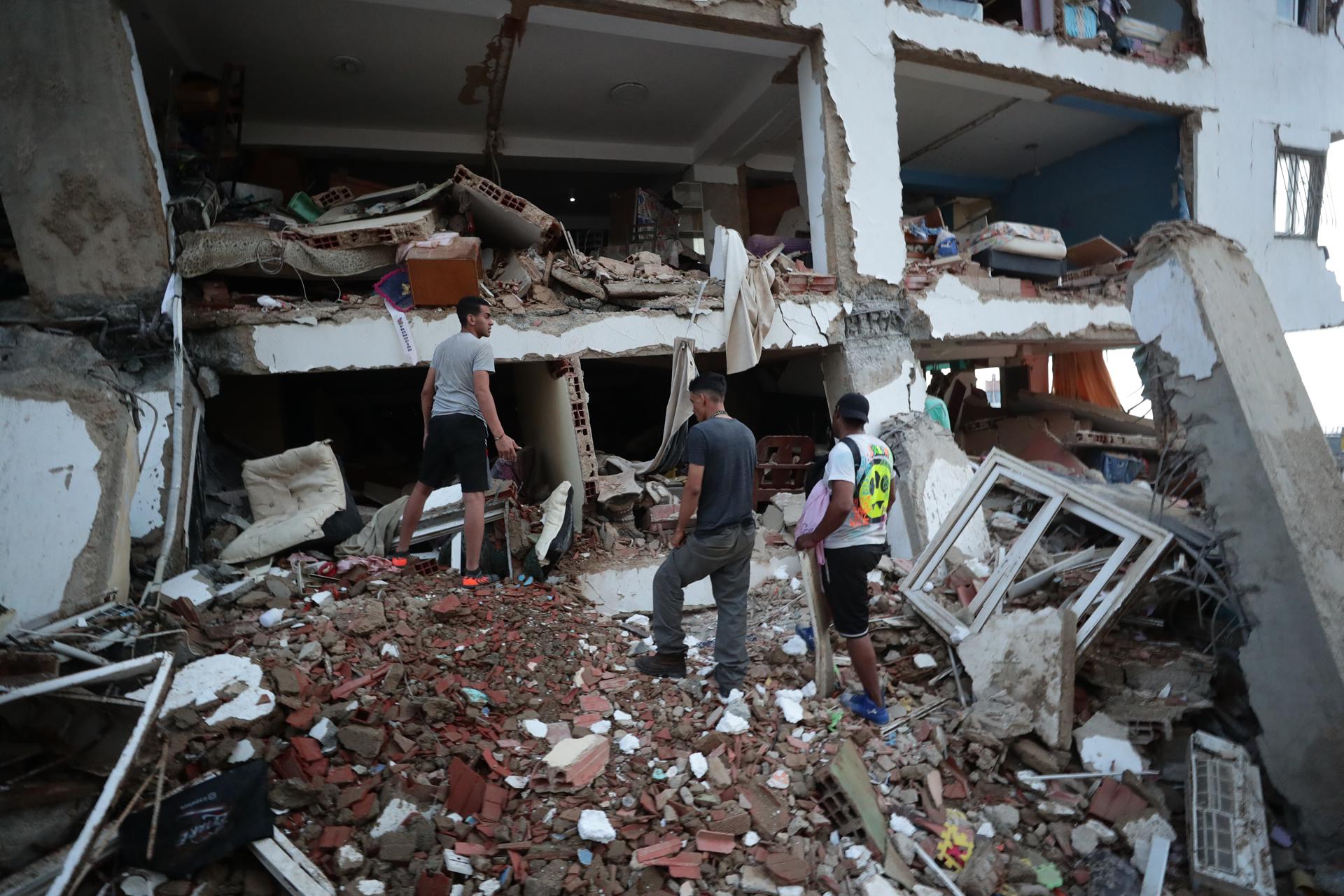 Residentes entre los escombros de uno de los bloques de viviendas dañados por los terremotos en la localidad de Catia La Mar, en el estado costero de La Guaira (Venezuela) este jueves. EFE/ Ronald Pena R.
