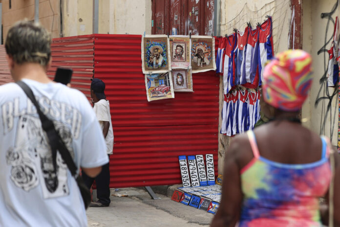Fotografía del 6 de Junio de 2026 de personas caminando junto a un lugar de venta de artesanías en La Habana (Cuba). EFE/ Ernesto Mastrascusa

