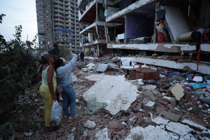Residentes entre los escombros de uno de los bloques de viviendas dañados por los terremotos, en la localidad de Catia La Mar, en el estado costero de La Guaira (Venezuela) este jueves. EFE/ Ronald Pena R.
