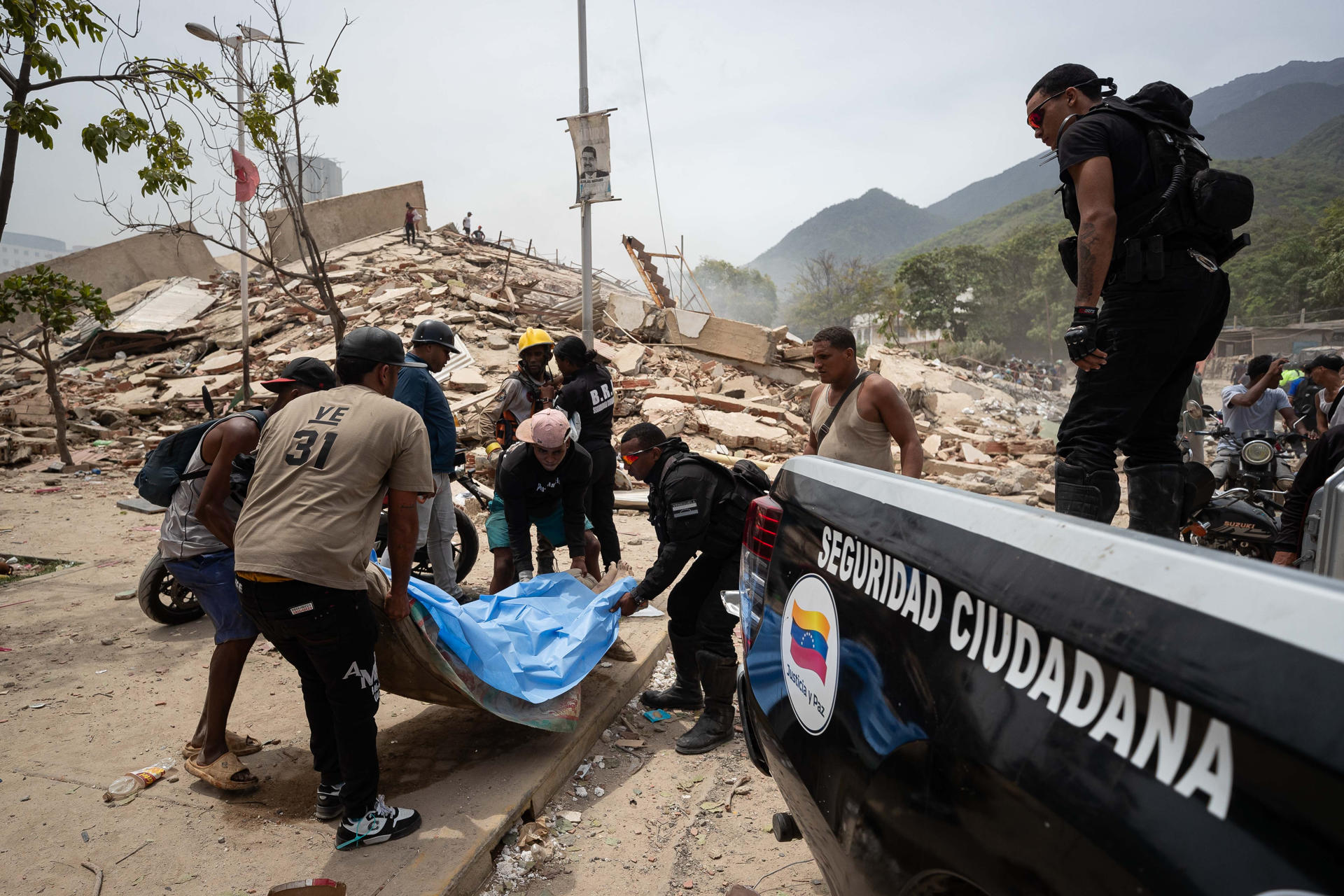 Voluntarios rescatan un cuerpo este jueves, entre los escombros de edificios afectados por los terremotos en La Guaira (Venezuela).EFE/ Ronald Peña R.
