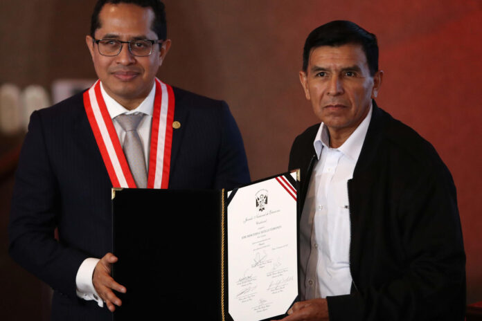 El presidente del Jurado Nacional Electoral (JNE) de Perú, Roberto Burneo (i), entrega la credencial de senador al hermano del expresidente Pedro Castillo (2021-2022), José Mercedes Castillo, este jueves en Lima (Perú). EFE/ Paolo Aguilar
