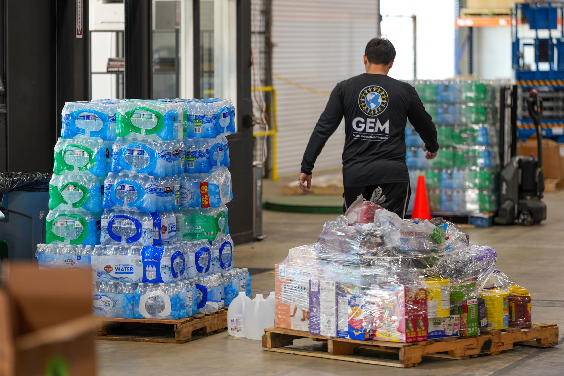 Un voluntario de Global Empowerment Mission (GEM) transporta alimentos este jueves, en la sede de la organización en Doral, Miami (Estados Unidos). EFE/ Alberto Boal
