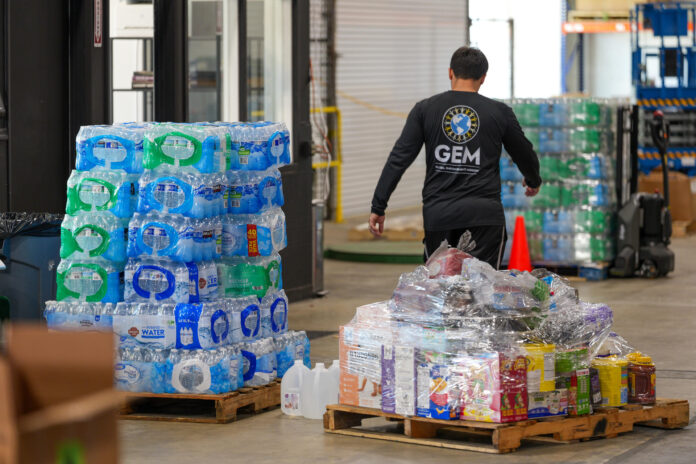 Un voluntario de Global Empowerment Mission (GEM) transporta alimentos este jueves, en la sede de la organización en Doral, Miami (Estados Unidos). EFE/ Alberto Boal
