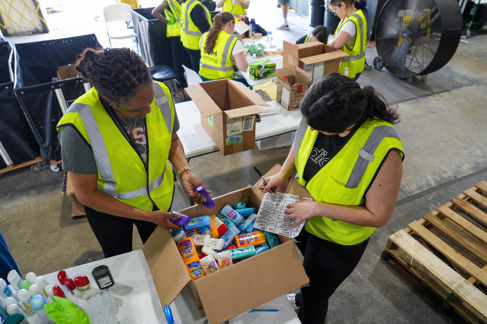 Voluntarias de Global Empowerment Mission (GEM) empacan cajas con alimentos este jueves, en la sede de la organización en Doral, Miami (Estados Unidos). EFE/ Alberto Boal
