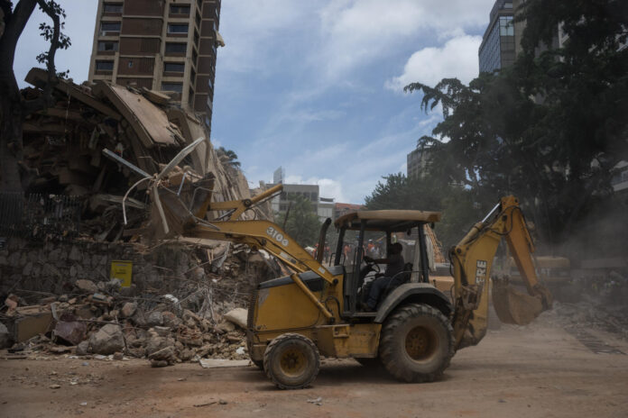 Un operario de maquinaria realiza labores de remoción de escombros este jueves, en el municipio Chacao en Caracas (Venezuela). EFE/ Boris Vergara
