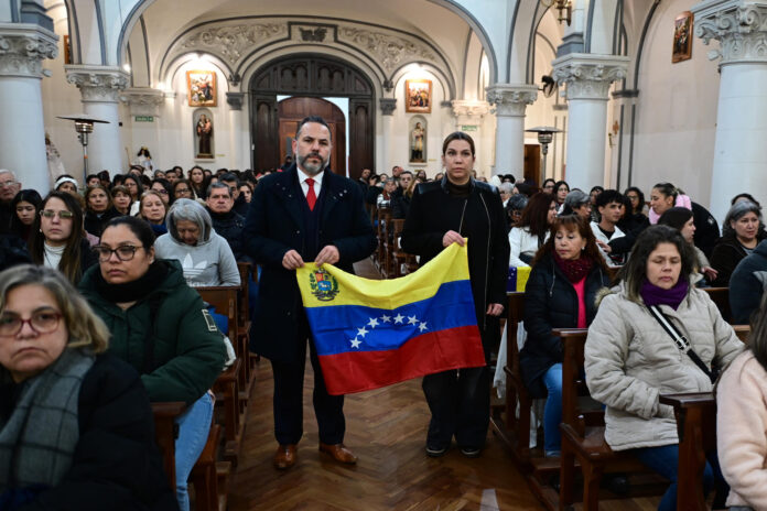 Personas sostienen una bandera de Venezuela este jueves, durante una misa por las víctimas del terremoto en Venezuela, en la Parroquia Nuestra Señora de Caacupé, en Buenos Aires (Argentina). EFE/ Matías Martín Campaya
