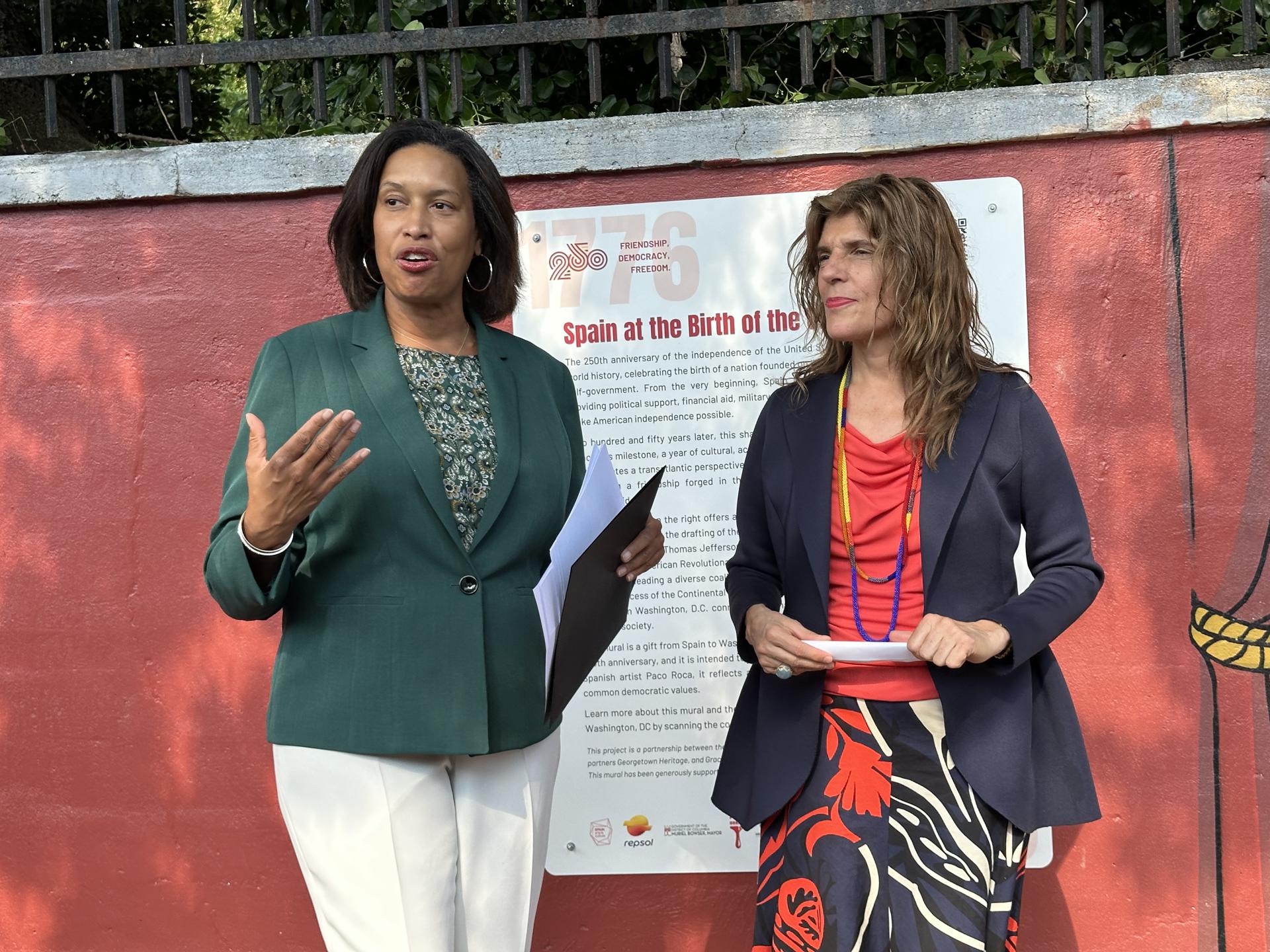La alcaldesa de Washington, Muriel Bowser (i), habla junto a la embajadora de España en Estados Unidos, Ángeles Moreno Bau, durante la inauguración del mural 'Spain at the birth of the United States' (España en el nacimiento de los Estados Unidos), diseñado por el ilustrador español Paco Roca en Washington (Estados Unidos). EFE/ Stefani Raguso
