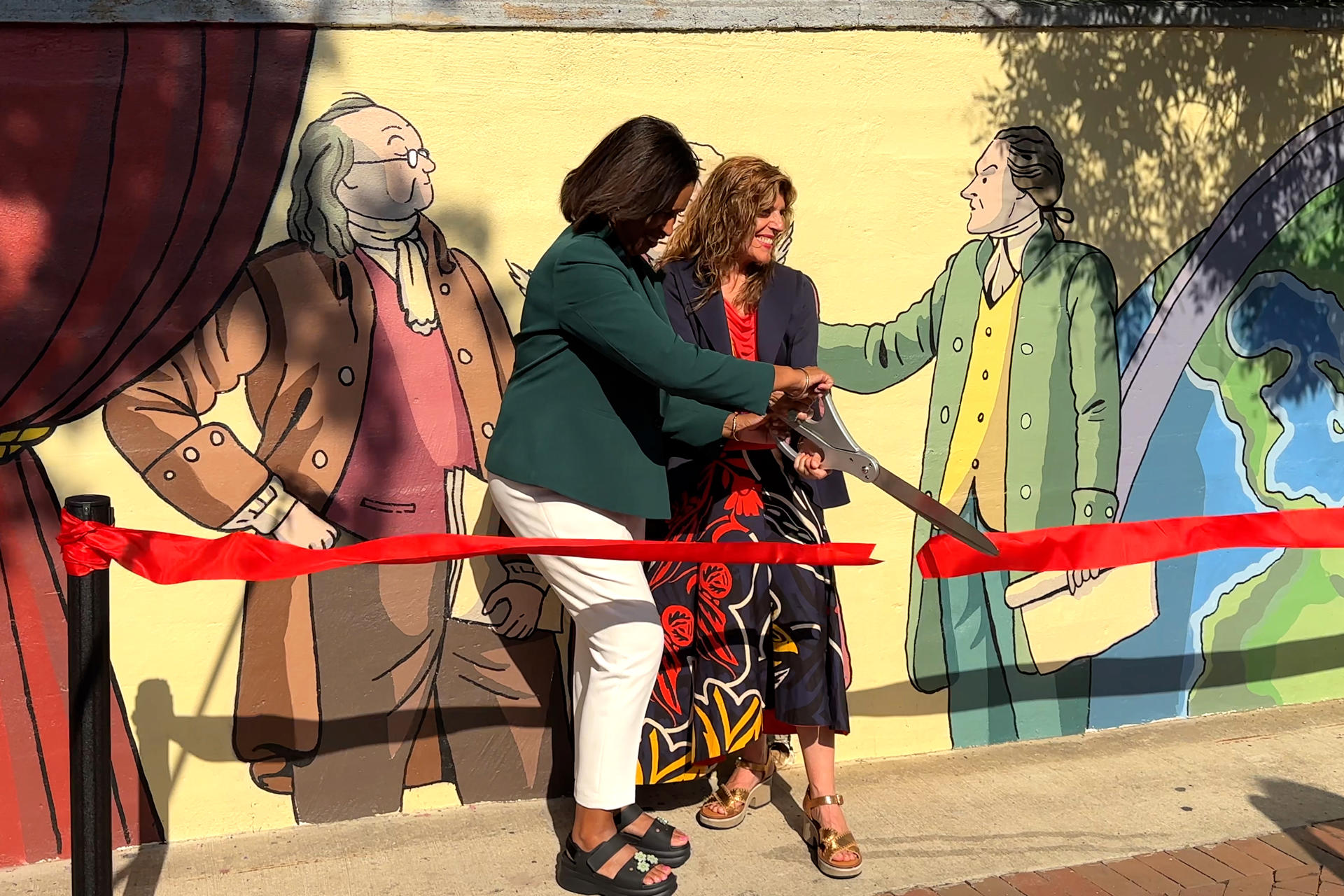 La alcaldesa de Washington, Muriel Bowser (i), y la embajadora de España en Estados Unidos, Ángeles Moreno Bau, inauguran el mural 'Spain at the birth of the United States' (España en el nacimiento de los Estados Unidos), diseñado por el ilustrador español Paco Roca en Washington (Estados Unidos). EFE/ Stefani Raguso
