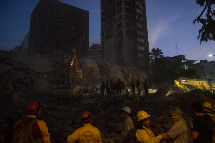 Integrantes de equipos de rescate trabajan este jueves, en un edifico afectado por un terremoto en la zona de Altamira en Caracas (Venezuela). EFE/ Boris Vergara
