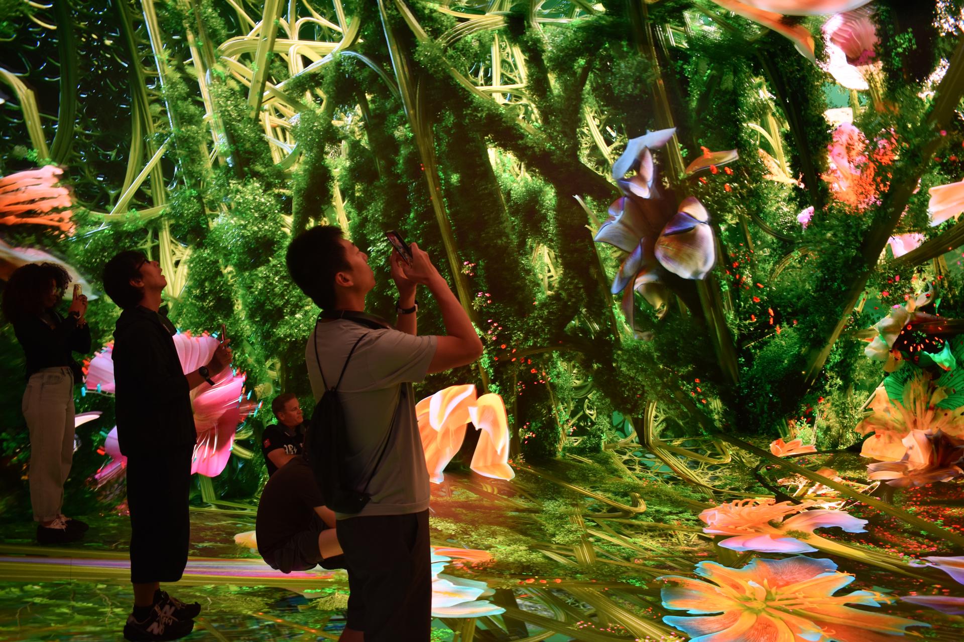 Personas observan la exposición inmersiva 'Machine Dreams: Rainforest' (Sueños de máquina: Selva tropical) este lunes, en Dataland, el primer museo de IA, concebido por Refik Anadol Studio, en Los Ángeles (EE.UU.). EFE/ Mónica Rubalcava
