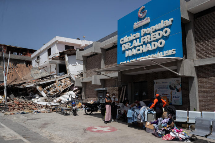 Personas aguardan este viernes, frente a la Clínica Popular Dr. Alfredo Machado en Catia La Mar (Venezuela). Familiares recorren distintos hospitales para intentar ubicar a sus parientes heridos o fallecidos tras los terremotos de 7,2 y 7,5 registrados la tarde del miércoles y que ha dejado, hasta el momento, un saldo de 920 personas muertas. EFE/ Ronald Peña R
