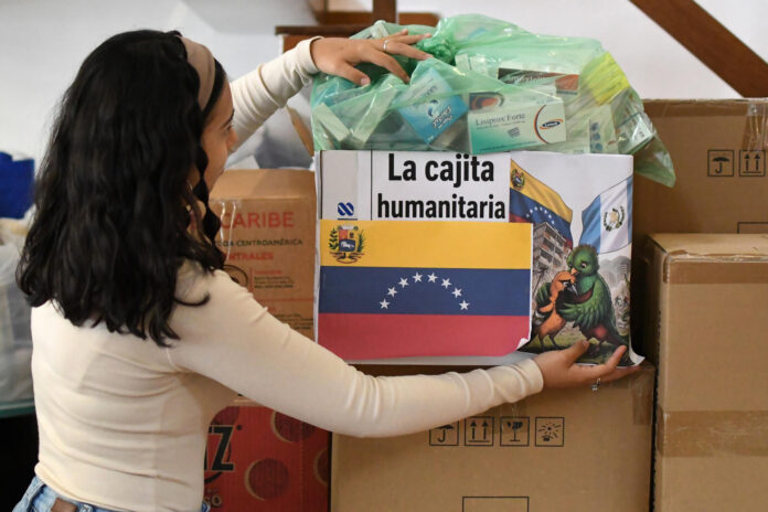 Una mujer fue captada este 26 de junio al marcar una caja con ayudas humanitarias para los damnificados por los terremotos en Venezuela, en Ciudad de Guatemala (Guatemala). EFE/Alex Cruz
