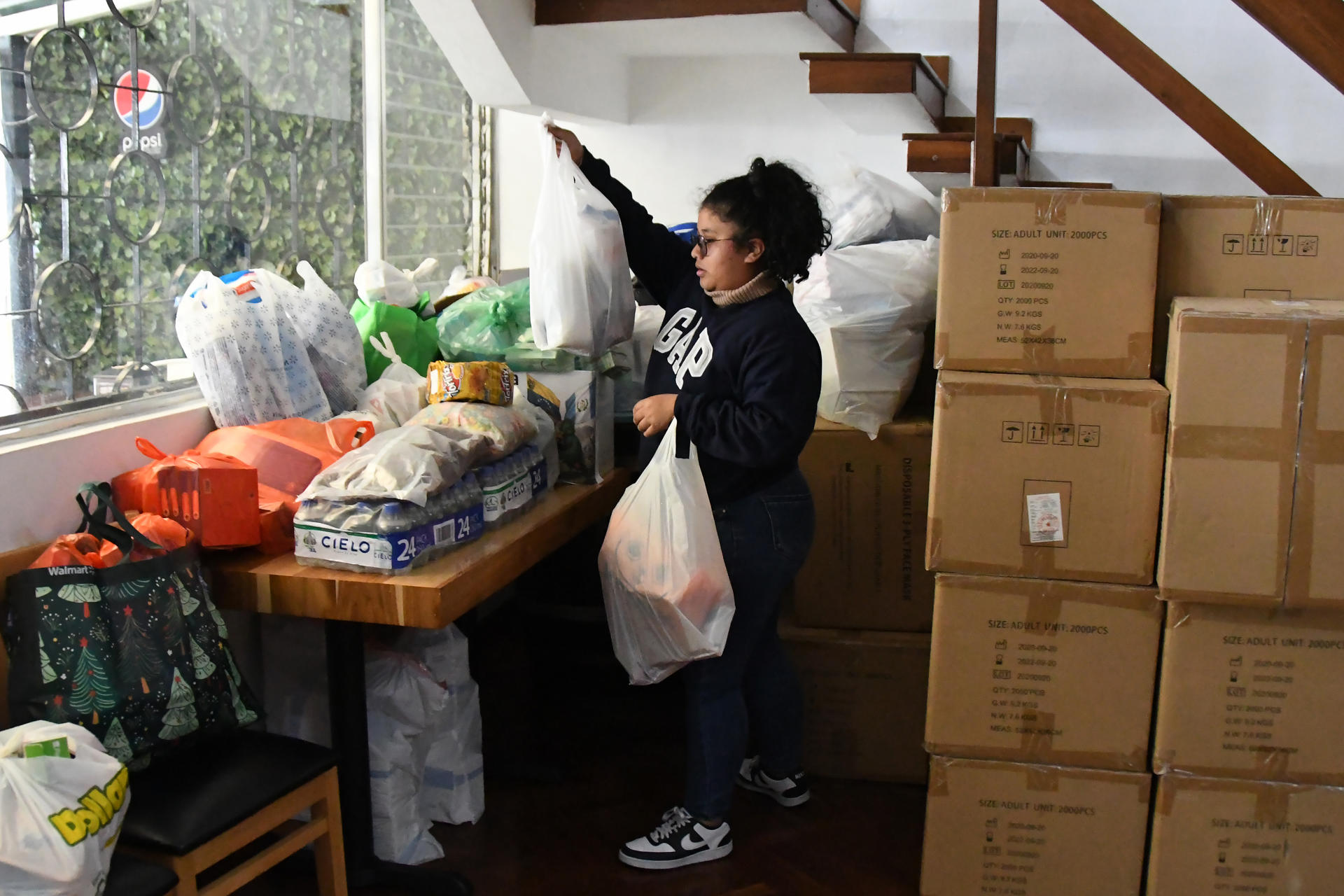Una mujer fue captada este 26 de junio al organizar cajas con ayudas humanitarias para los damnificados por los terremotos en Venezuela, en Ciudad de Guatemala (Guatemala). EFE/Alex Cruz
