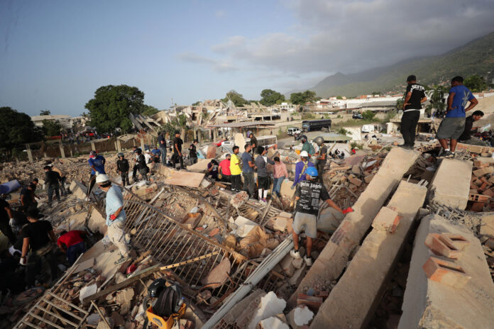 Personas realizan labores de búsqueda en una zona afectada por un terremoto, este viernes en La Guaira (Venezuela). EFE/ Ronald Peña R

