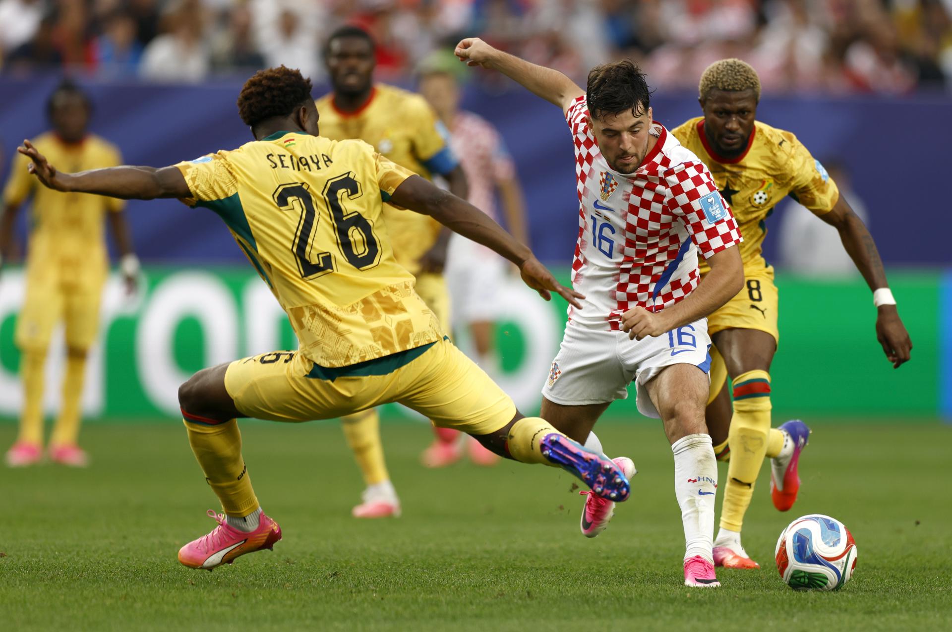 El croata Martin Baturina (c) se evade de la marca del ghanés Marvin Senaya (i) durante el partido de la última jornada del Grupo L del Mundial jugado en Philadelphia. EFE/EPA/WILL OLIVER
