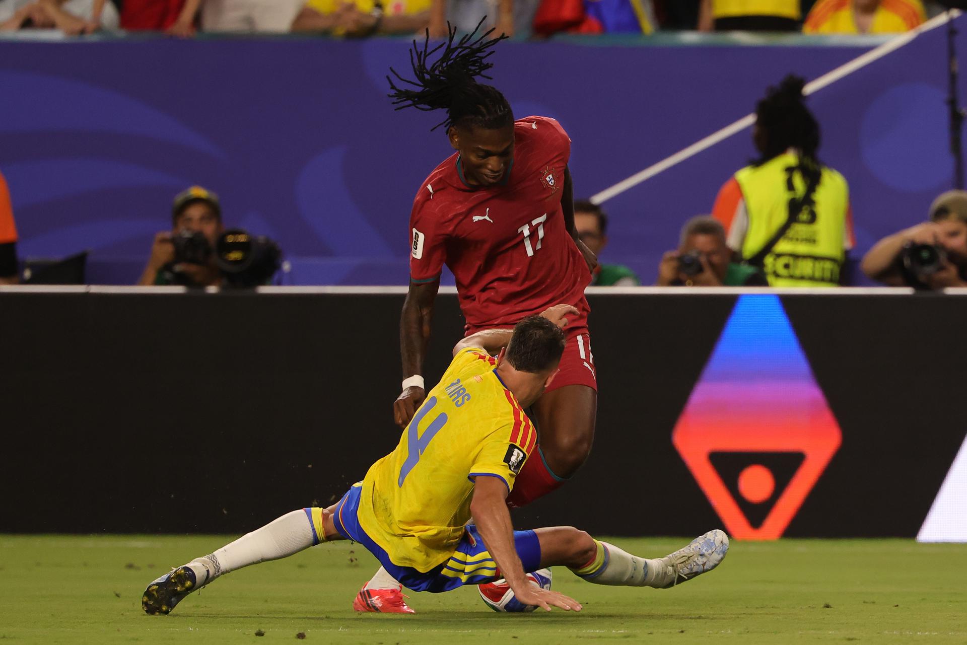 El defensor colombiano Santiago Arias se barre para cerrar el paso del portugués Rafael Leao (d) en el partido que quedó empatado 0-0 este sábado en Miami.EFE/EPA/CRISTOBAL HERRERA-ULASHKEVICH
