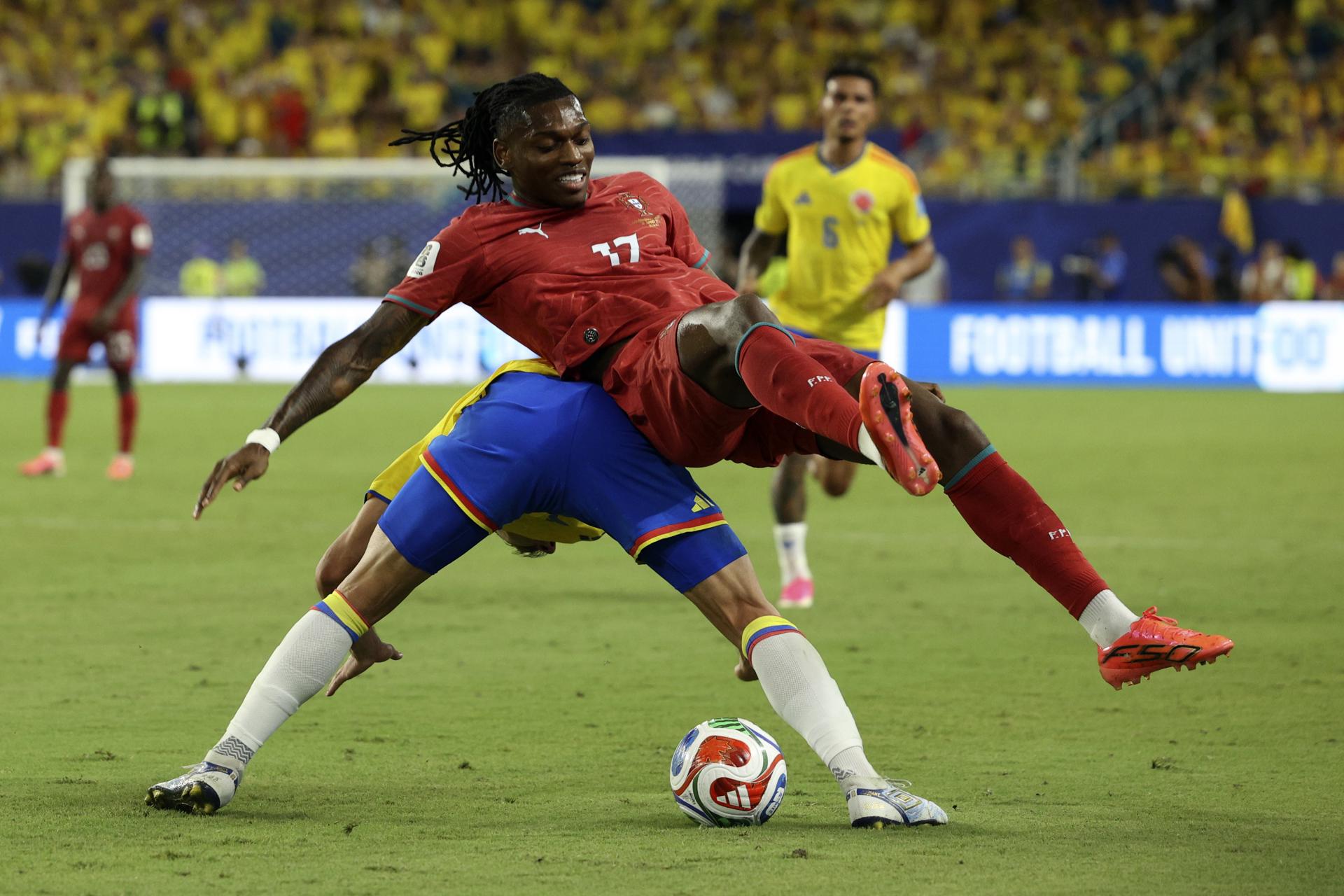 El colombiano Santiago Arias (i) soporta la oposición del portugués Rafael Leao (d) durante el partido que igualaron este sábado en Miami. EFE/EPA/MIGUEL A. LOPES
