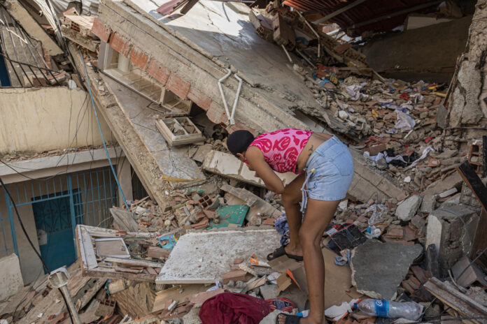 Una mujer busca entre los escombros de las edificaciones destruidas por los terremotos, este domingo, en Catia La Mar (Venezuela). EFE/ Henry Chirinos

