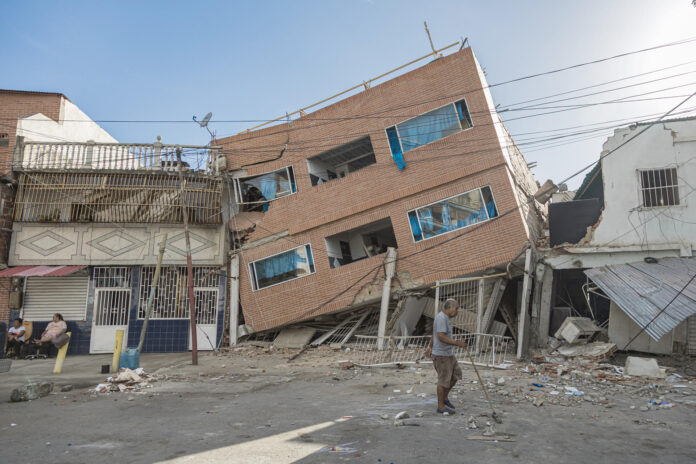 Un hombre camina frente a edificaciones destruidas por los terremotos, este domingo, en Catia La Mar (Venezuela). EFE/ Henry Chirinos
