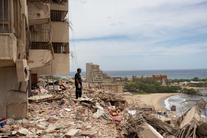 Un rescatista observa escombros en una zona afectada por los terremotos, este domingo, en Catia La Mar (Venezuela). EFE/ Ronald Peña R
