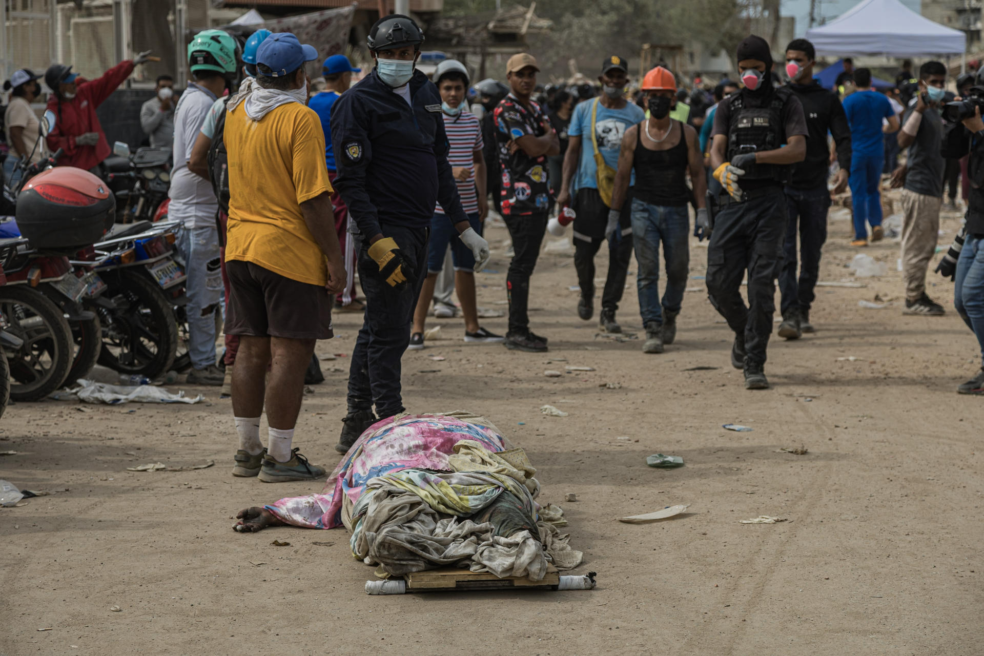 Vista general del cuerpo sin vida de una persona recuperada bajo los escombros, en medio de decenas de rescatistas y voluntarios, durante las labores de búsqueda y remoción de escombros tras los terremotos del pasado miércoles, en Tanaguaneras (La Guaira, Venezuela). EFE/Henry Chirinos
