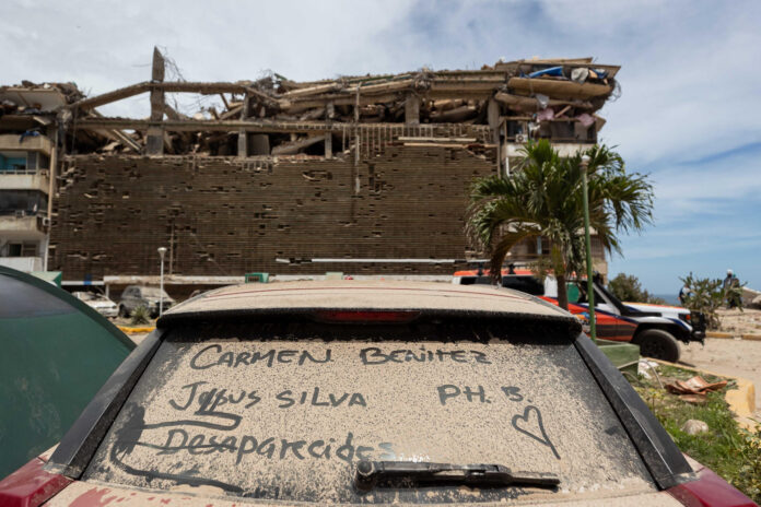 Detalle del vidrio panorámico de un automóvil cubierto de polvo y con los nombres de personas desaparecidas durante los terremotos del pasado miércoles, en Catia La Mar (Venezuela). EFE/ Ronald Peña
