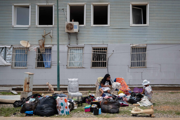 Personas fueron captadas este 28 de junio al esperar frente a un edificio afectado por los terremoto del pasado miércoles, en Catia La Mar (La Guaira, Venezuela). EFE/Ronald Peña
