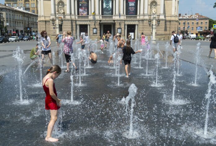 Un grupo de personas se refresca del calor provocado por las altas temperaturas en la ciudad ucraniana de Leópolis. EFE/EPA/MYKOLA TYS
