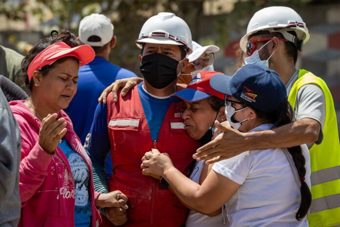 Personas reaccionan durante las labores de búsqueda este lunes, en La Guaira (Venezuela). EFE/ Ronald Peña R
