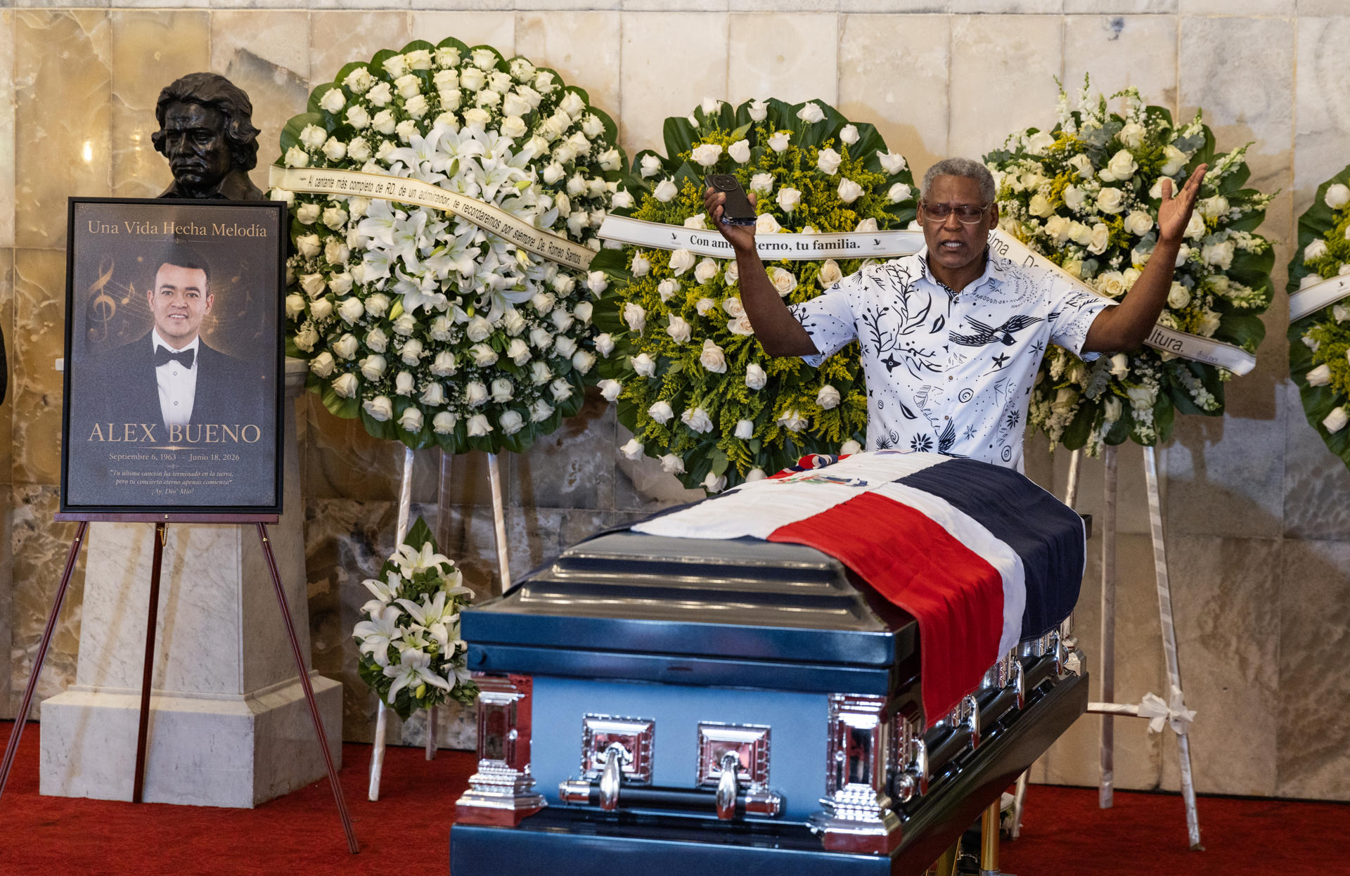 Una persona hace una oración frente al féretro del fallecido cantante dominicano Alex Bueno durante el velorio en el Teatro Nacional este lunes, en Santo Domingo (República Dominicana). EFE/Orlando Barría
