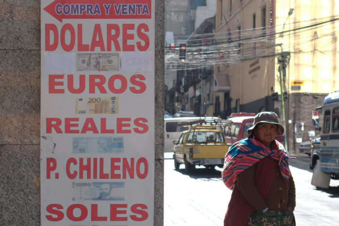 Una mujer aimara camina frente a una casa de cambio este lunes, en La Paz (Bolivia). EFE/Luis Gandarillas
