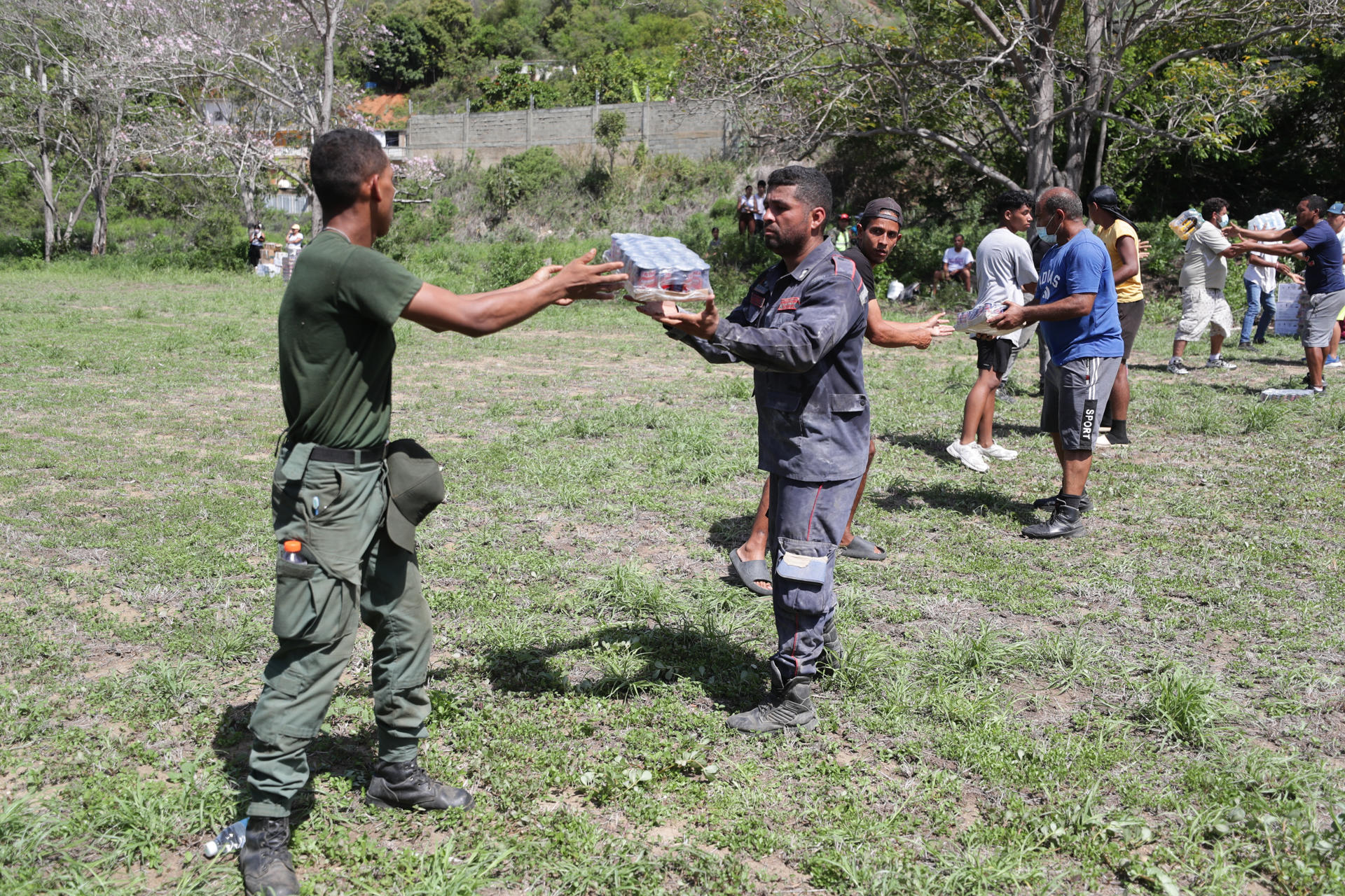 Personas descargan ayudas humanitarias de un helicóptero este lunes, en La Guaira (Venezuela). EFE/ Ronald Peña R

