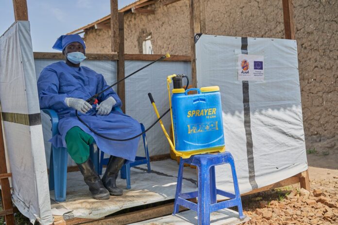 Un hombre con un traje de protección opera un pulverizador lleno de desinfectante en un centro de tratamiento de Ébola gestionado por la ONG Alianza para la Acción Médica (ALIMA) en Rwampara, Ituri, República Democrática del Congo, 20 de junio de 2026. EFE/EPA/DIEUDONNE DIROLE
